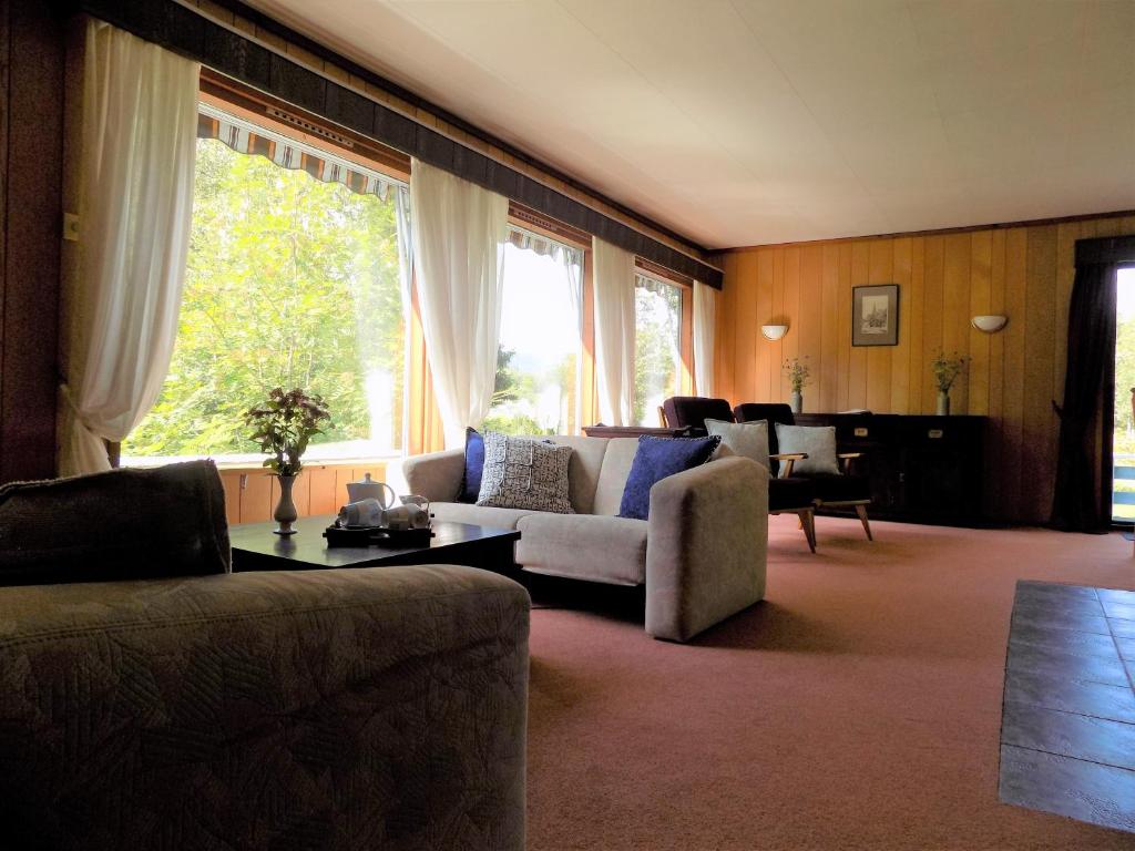 ÅheimKråkehaugen Feriehus, a perfect holiday retreat near Åheim的带沙发和大窗户的客厅