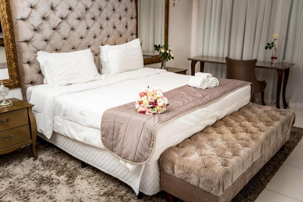 里约热内卢波萨达瓜纳巴拉花园酒店的一间卧室配有一张带鲜花的大床