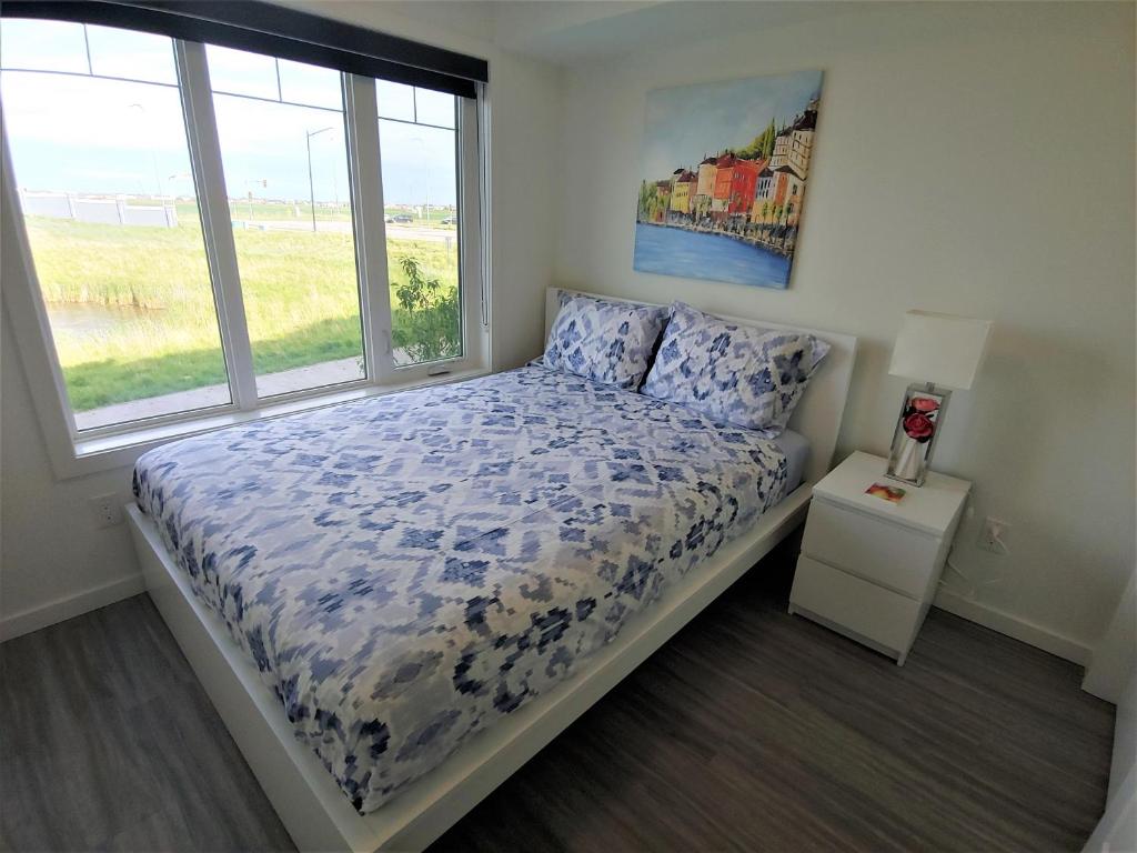 温尼伯Serene 2 bedroom condo with balcony and lakeview的一间卧室设有一张床和一个窗口