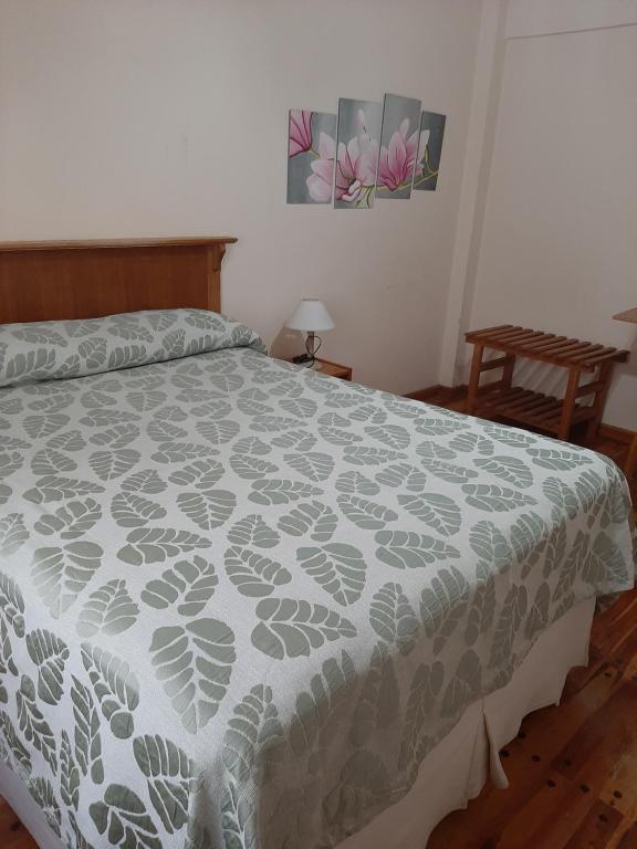 玛德琳港LOWCOST MADRYN的卧室配有一张带灰色和白色床单的床。