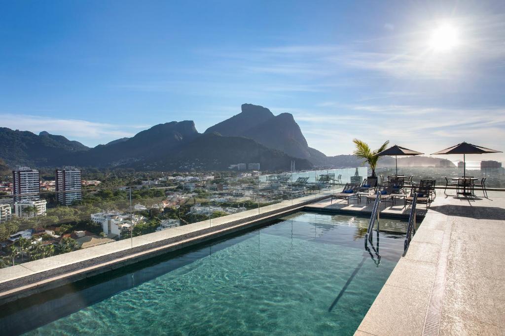 里约热内卢Windsor Tower Hotel的一座大楼的顶部,设有一座带椅子和遮阳伞的游泳池