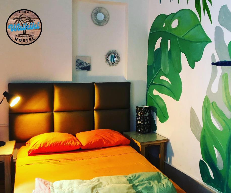 利马Waikiki Hostel的一间卧室配有一张带橙色床头板的床