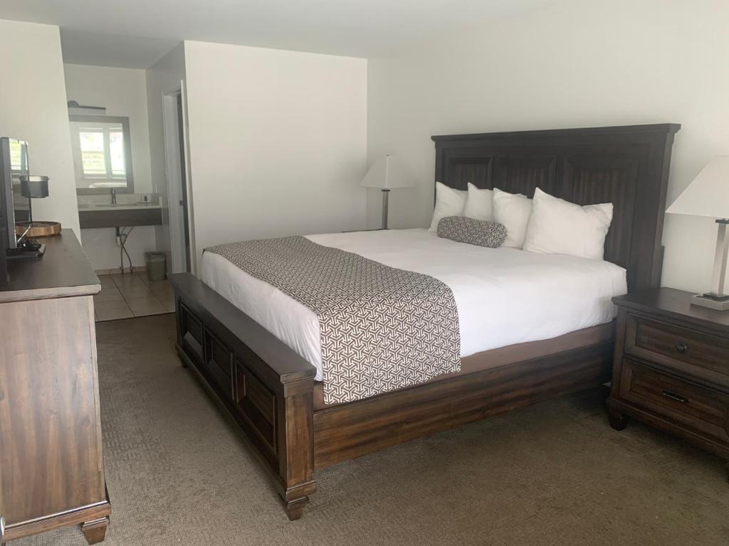 格伦伍德温泉悬湖旅馆的卧室配有一张带白色床单和枕头的大床。