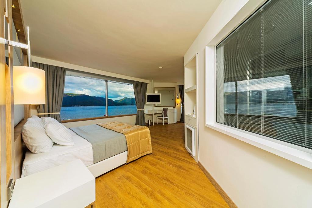 马尔马里斯Poseidon Hotel - Adult Only的一间卧室设有一张床和一个大窗户