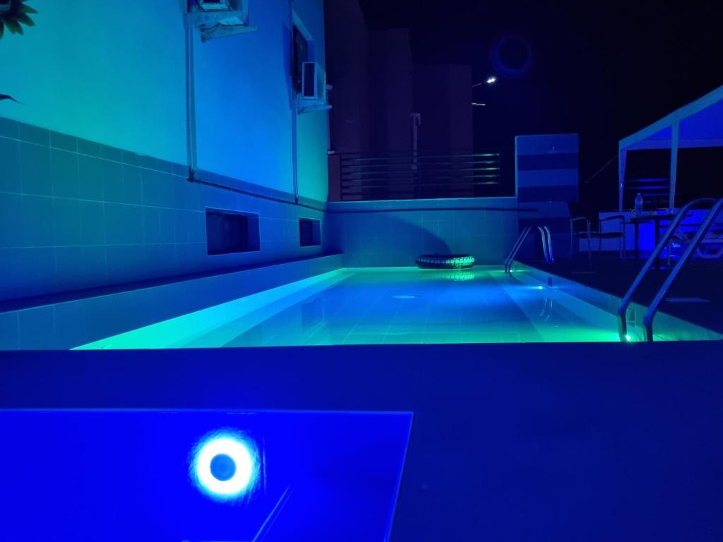 ThièsRésidence Blue hôtel的室内的游泳池,有蓝色的灯光