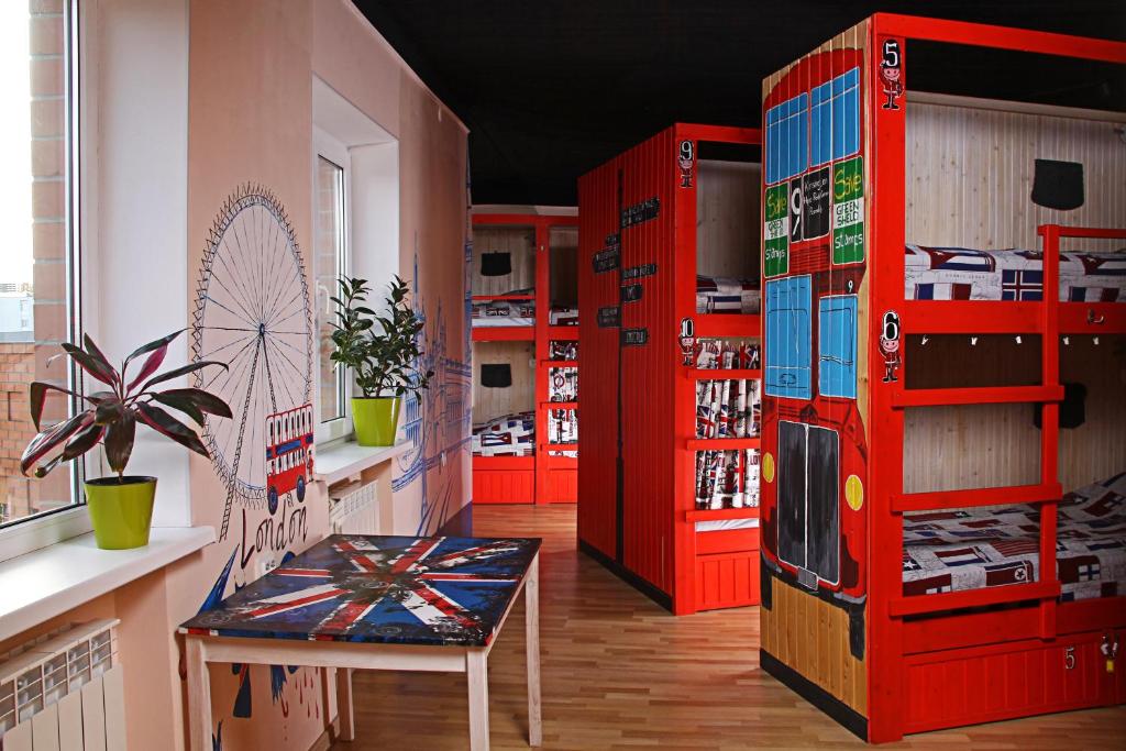 派蒂哥斯卡Хостел Жить просто 2的一间设有红色架子、一张桌子和椅子的房间