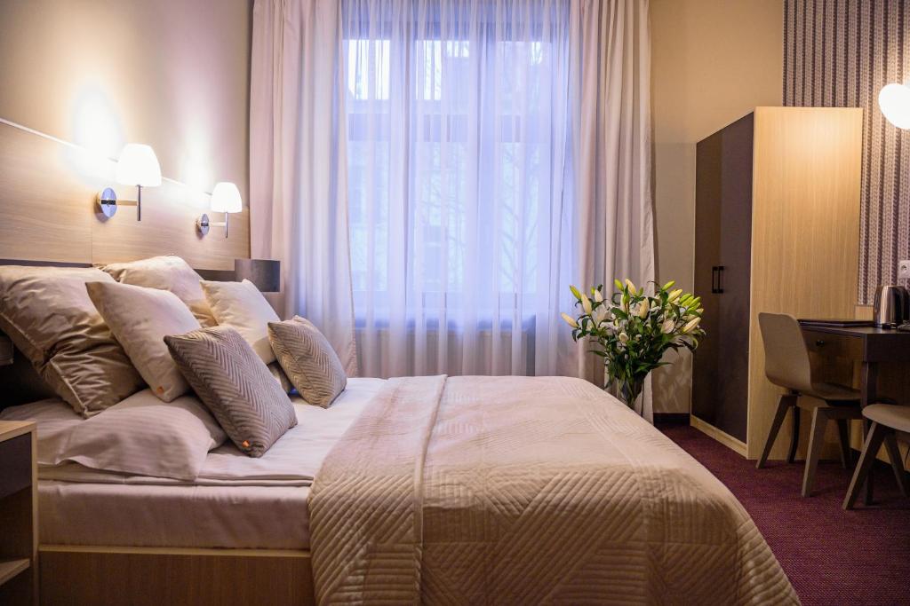克拉科夫卡齐米2号酒店的一间卧室设有一张大床和窗户