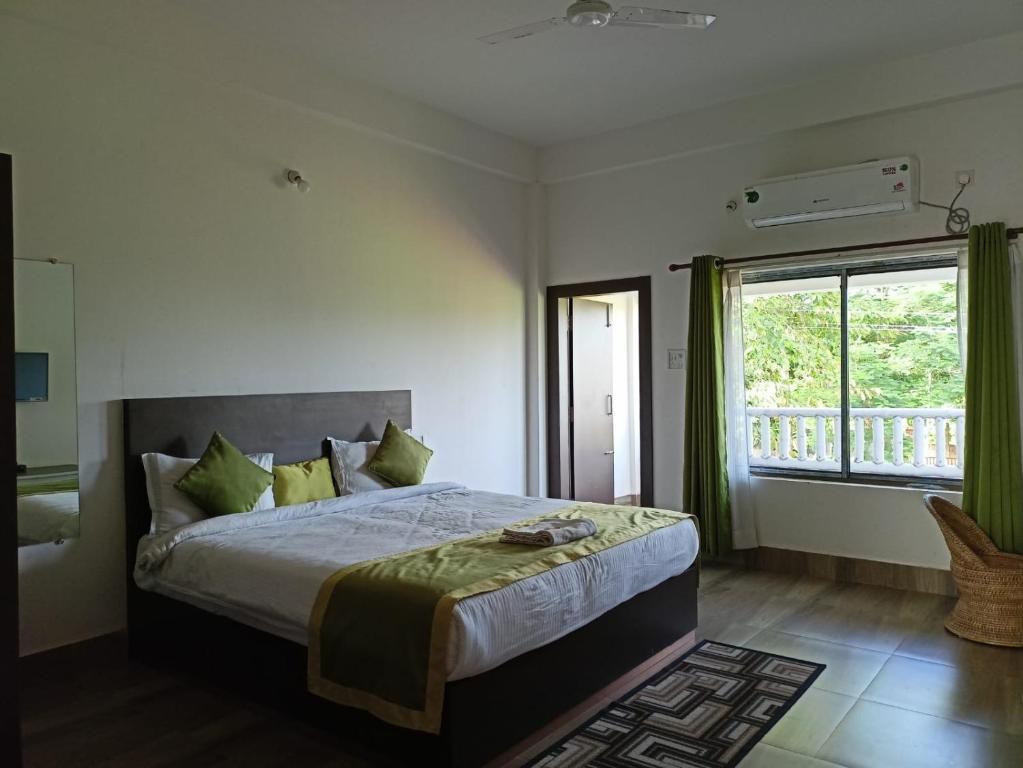 卡齐兰加Shivaji Inn Kaziranga的一间卧室设有一张大床和一个窗户。