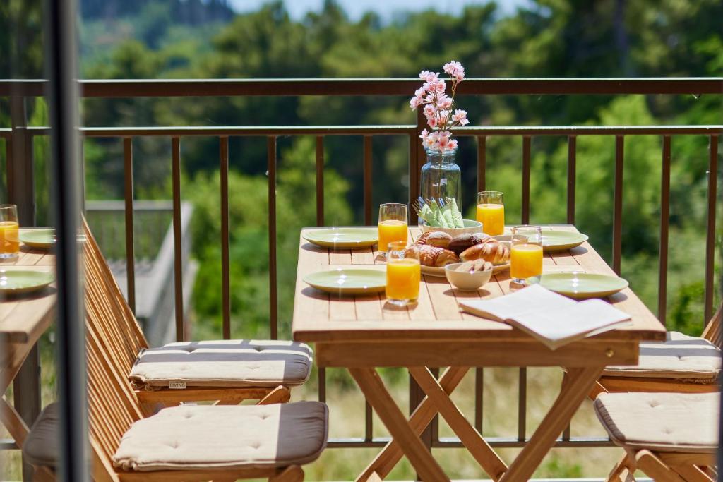 蒂瓦特Dimitris Apartments的阳台上配有一张带食品和饮料的木桌