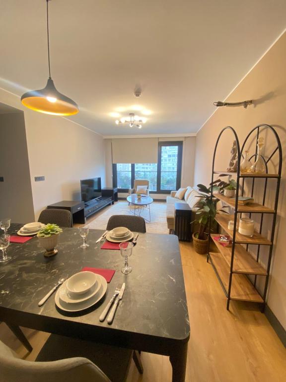伊斯坦布尔Luxury Central Fully Equipped 2BR 2BA Apartment by Siena Suites的用餐室以及带桌椅的起居室。