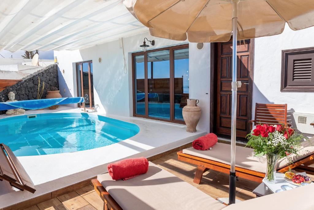阿索马达Finca La Casita的一座带游泳池和遮阳伞的别墅