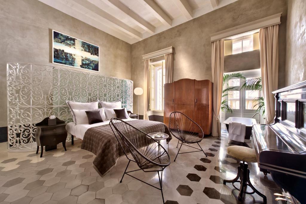 瓦莱塔Casa Ellul - Small Luxury Hotels of the World的一间卧室配有床、椅子和钢琴