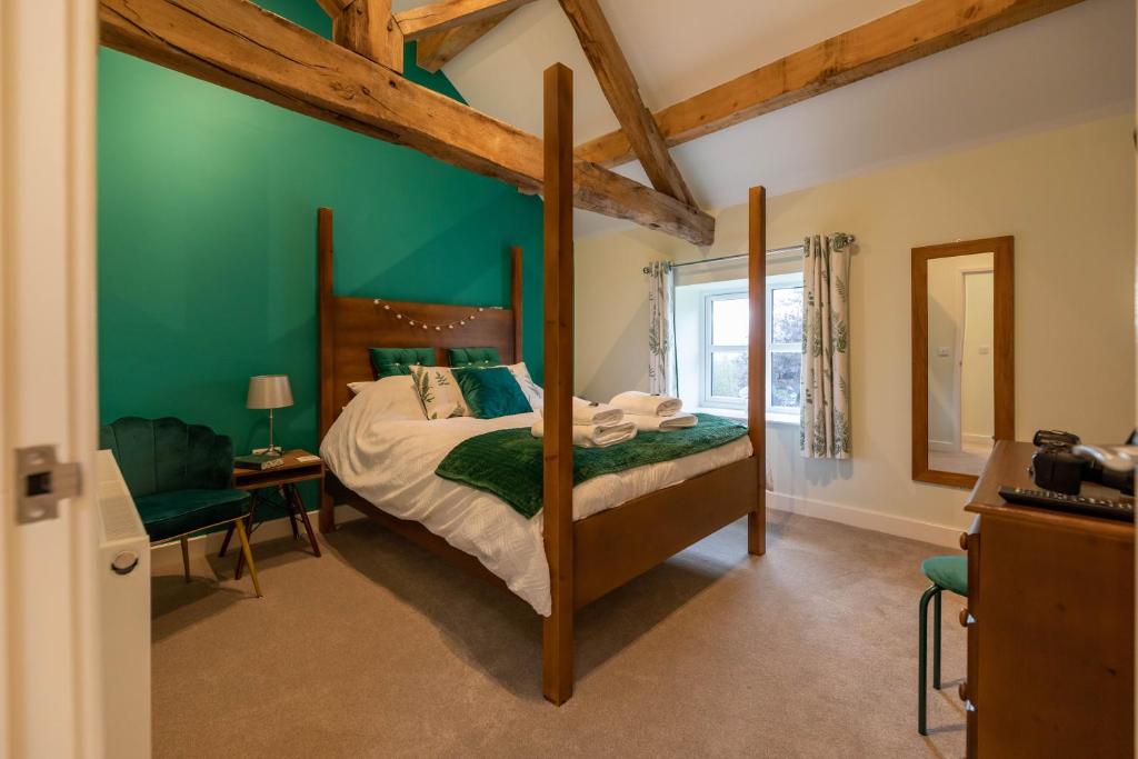 登比Dyffryn Cottage - King bed, self-catering cottage with Hot Tub的一间卧室设有一张床和绿色的墙壁