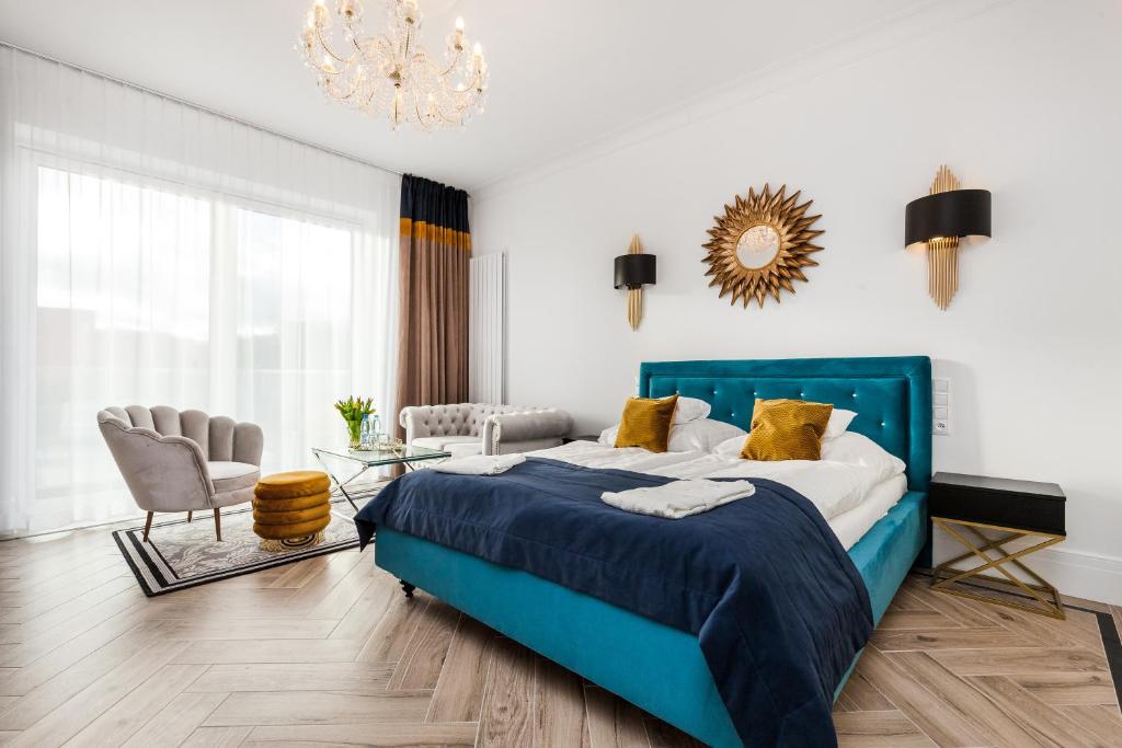 格但斯克Prawdzic Family Resort & Wellness的一间卧室配有蓝色的床和吊灯。