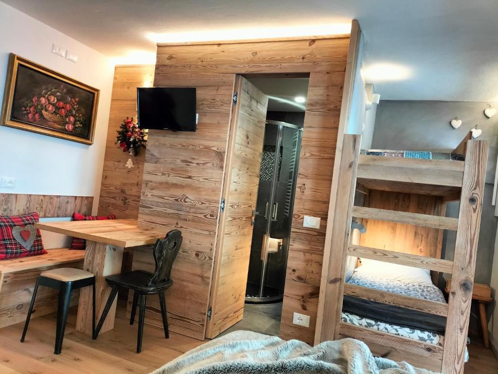 摩德纳迪-坎皮格里奥Appartamento Campiglio 2的客房设有一张桌子和一张双层床。