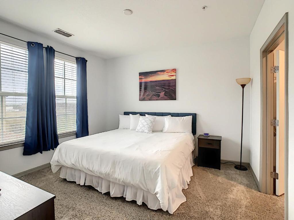基西米King Bed And Close To Disney的卧室配有一张带蓝色窗帘的大型白色床