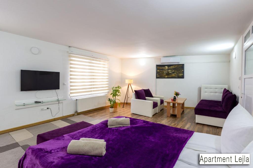 图兹拉Pansion Beg的客厅配有紫色的床和电视