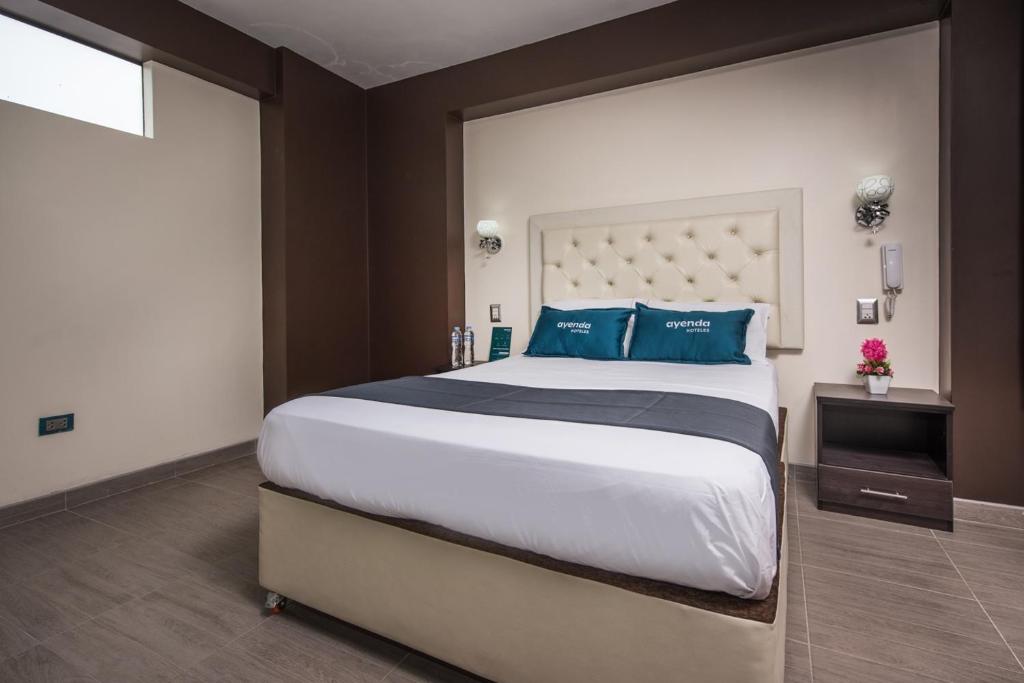 库斯科Olimpo Hotel Sauna & Spa的一间卧室配有一张带蓝色枕头的大床