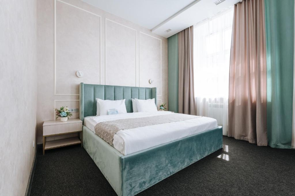 伊热夫斯克Panorama Hotel的一间卧室设有一张床和一个大窗户