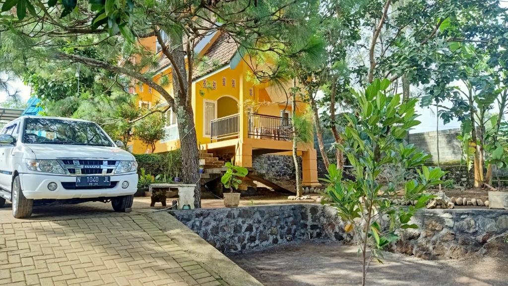 巴图Homestay Sinar Bulan的停在黄色房子前面的白色货车