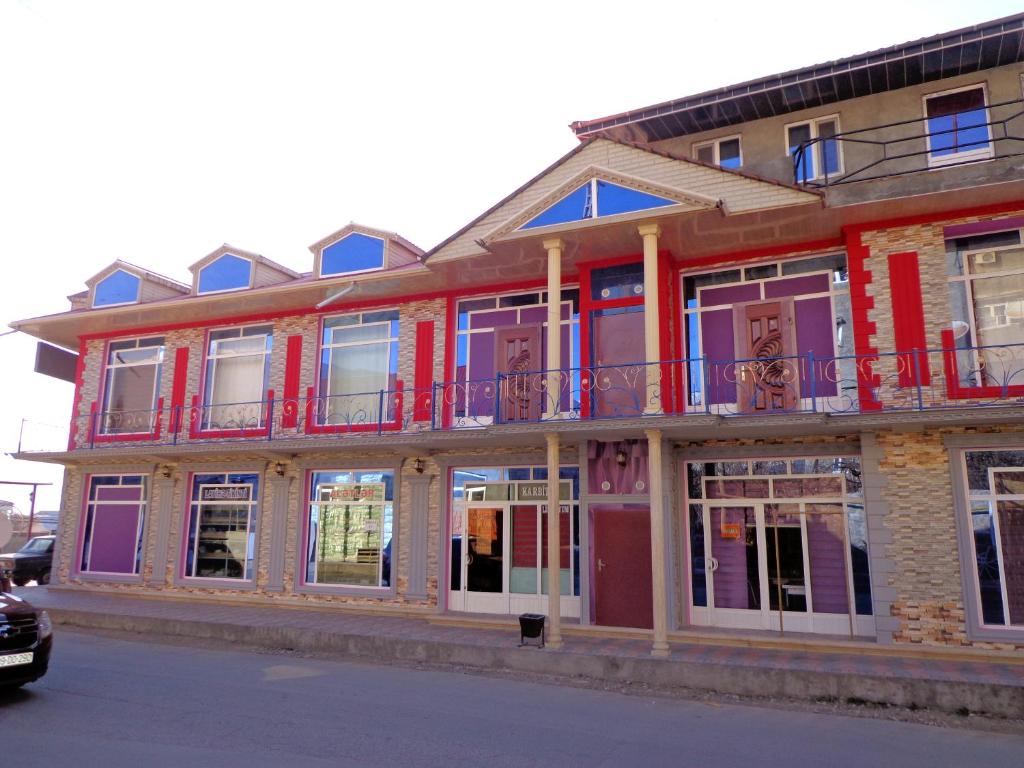 舍基Tubram S Ailəvi Qonaq Evi的街道上设有窗户和阳台的建筑