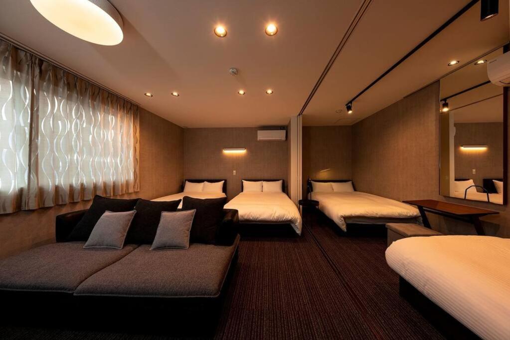 福冈White Crystal RoomB的酒店客房,设有两张床和一张沙发