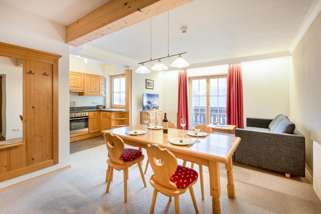 恩斯塔尔豪斯松嫩贝格公寓的厨房以及带木桌和椅子的客厅。