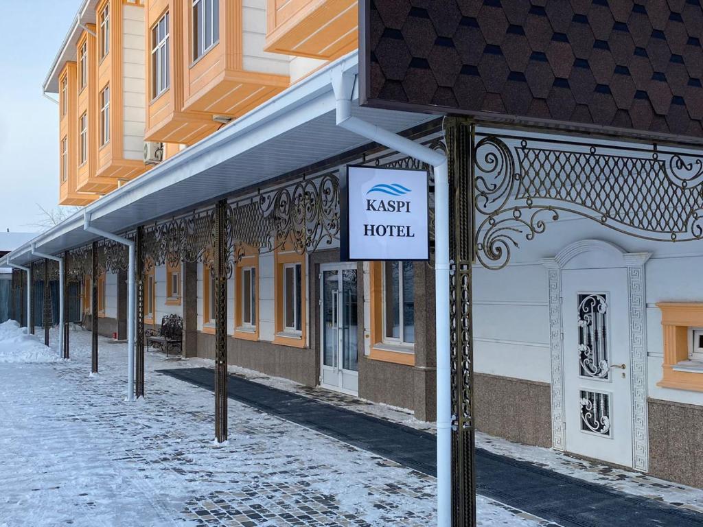乌拉尔斯克Kaspi Hotel的建筑物前的街道上的一个标志