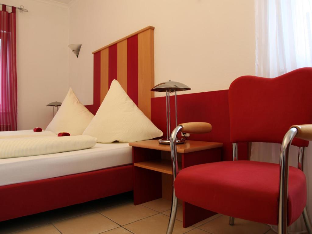 杜塞尔多夫卡萨别墅酒店的酒店客房,设有两张床和一张红色椅子
