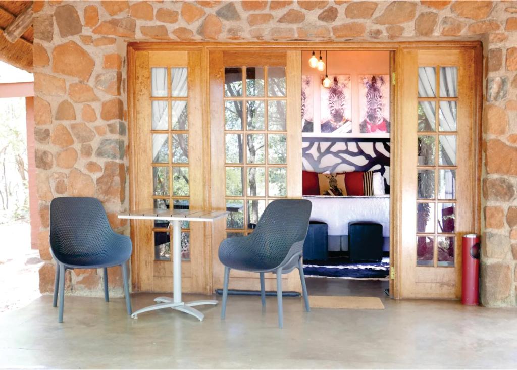 哈博罗内Waterside Cottages的一间设有两把椅子和一张桌子的房间,窗户