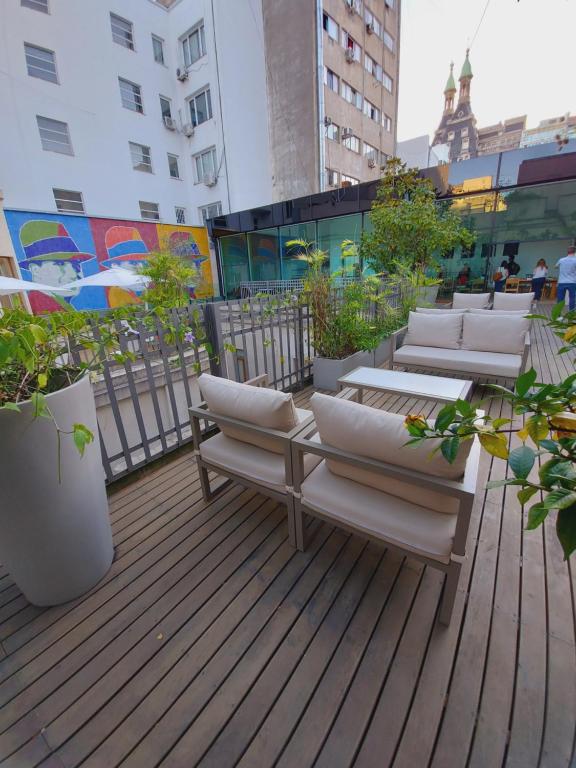 布宜诺斯艾利斯Cassa Lepage Art Hotel Buenos Aires的建筑中带椅子和植物的甲板