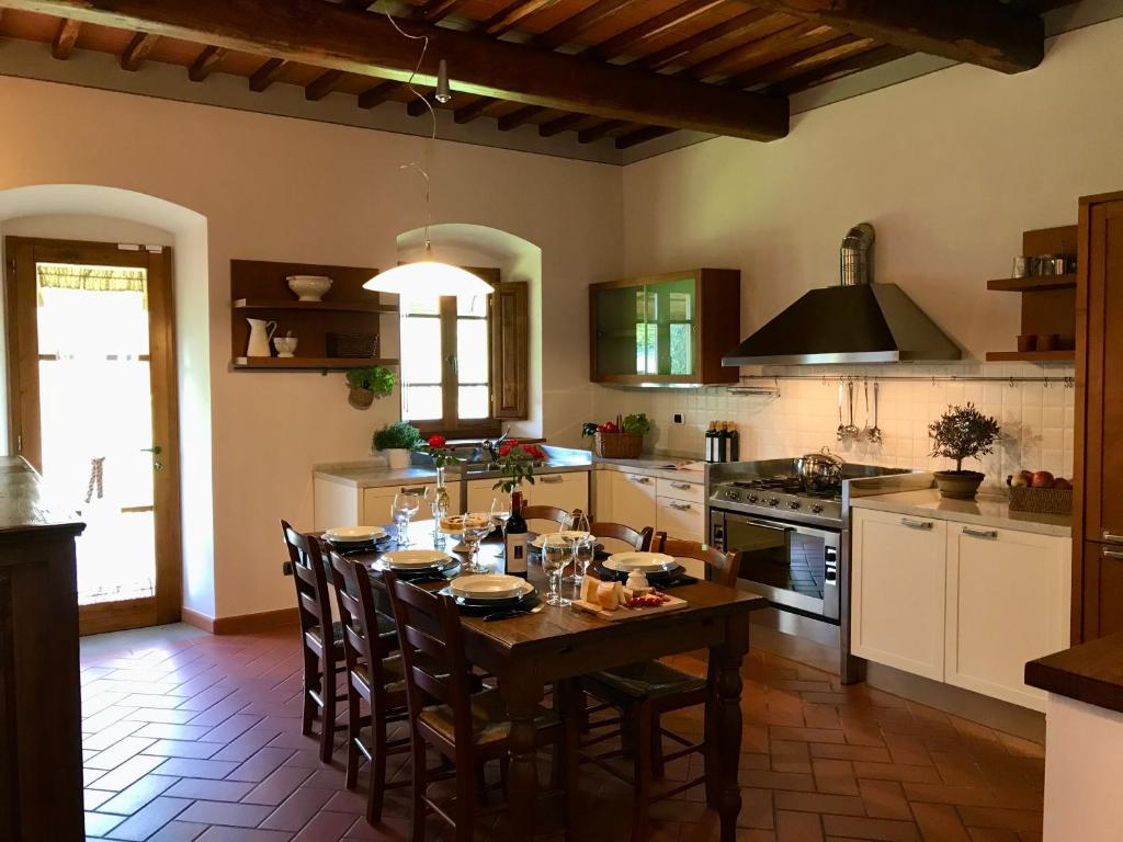 圣焦万尼瓦尔达尔诺Agriturismo Podere Filicaia的厨房配有木桌和椅子