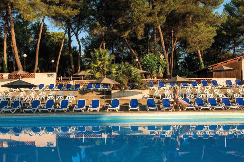 卢河畔拉科尔Belambra Clubs La Colle-sur-Loup - Les Terrasses De Saint-Paul De Vence的一个带椅子和遮阳伞及树木的游泳池