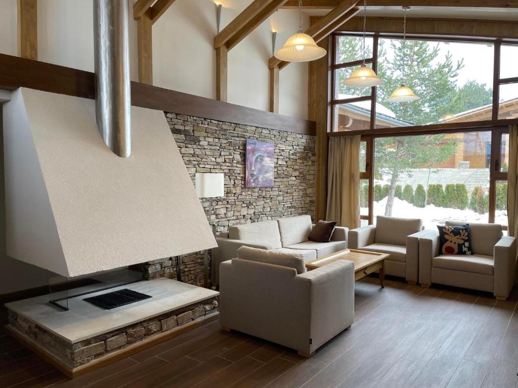 班斯科Villa Tama Pirin Golf and Spa的带沙发和壁炉的客厅