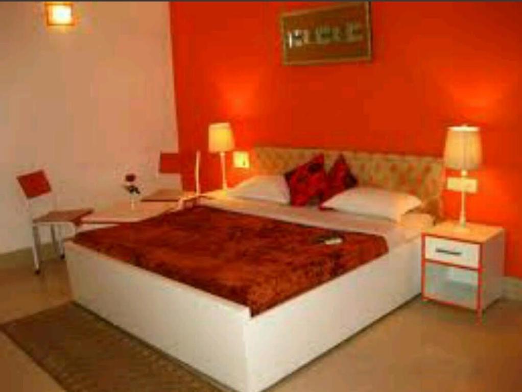 密拉特Hotel travel inn的一间卧室设有一张红色墙壁的大床