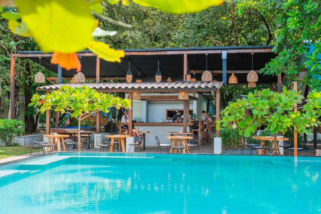 普拉纳维瑙Selina River Venao的游泳池位于餐厅前,配有桌椅