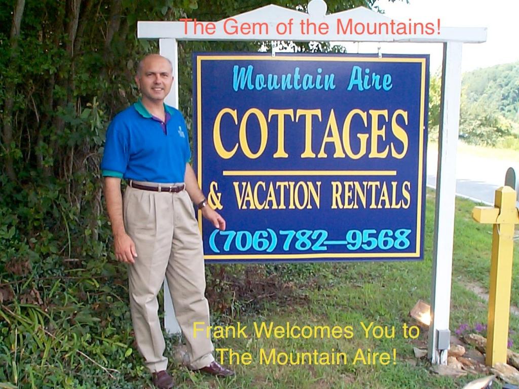 克莱顿Mountain Aire Cottages & Inn的一个人站在标志前