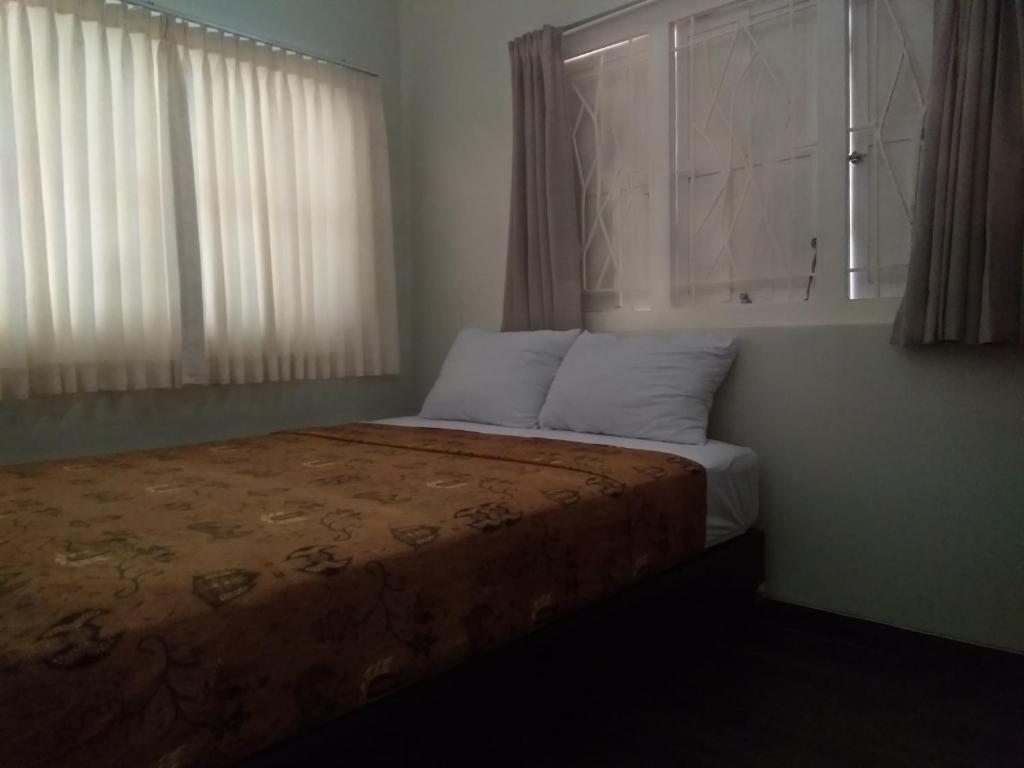 日惹Omah Ngadiwinatan Syariah的一间卧室配有一张带窗户和浴缸的床。