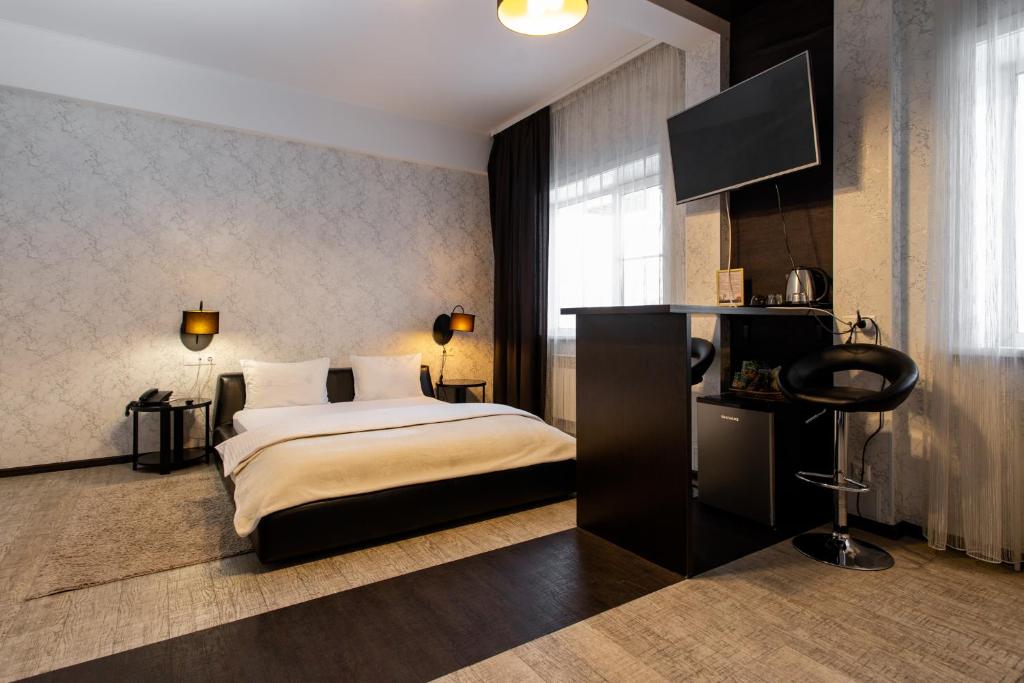 伊尔库茨克多罗格7号酒店的一间卧室配有一张床和一台平面电视