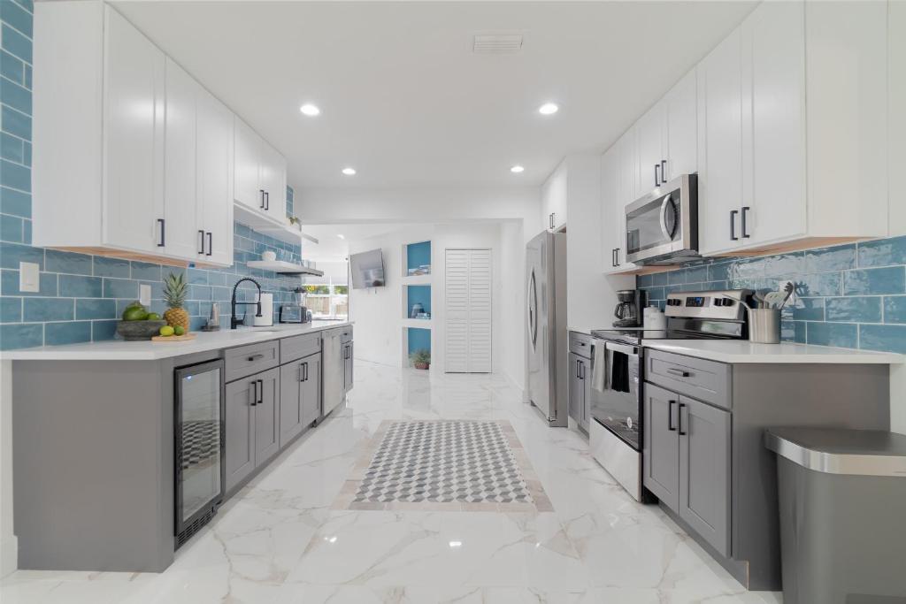 西棕榈滩Elegant 5BR West Palm Beach Home Near Beach的厨房配有白色橱柜和蓝色瓷砖