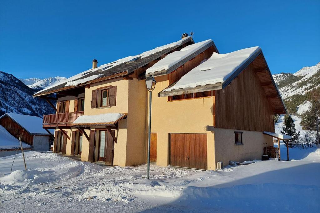 内瓦什Le Vallon des âmes - Large house for 15 people in Roubion的山间的房子被雪覆盖