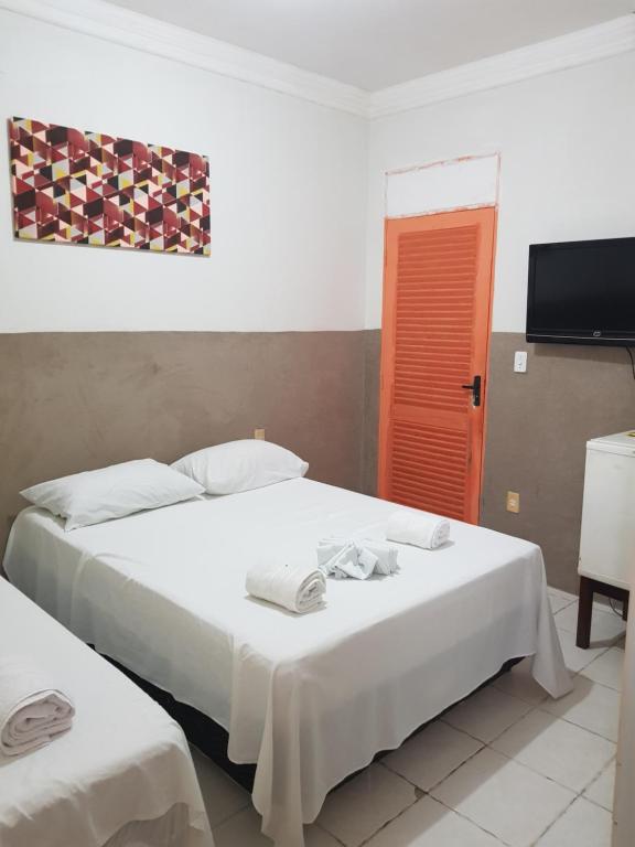 若昂佩索阿Pousada Manaíra Buena Playa的酒店客房设有两张床和电视。