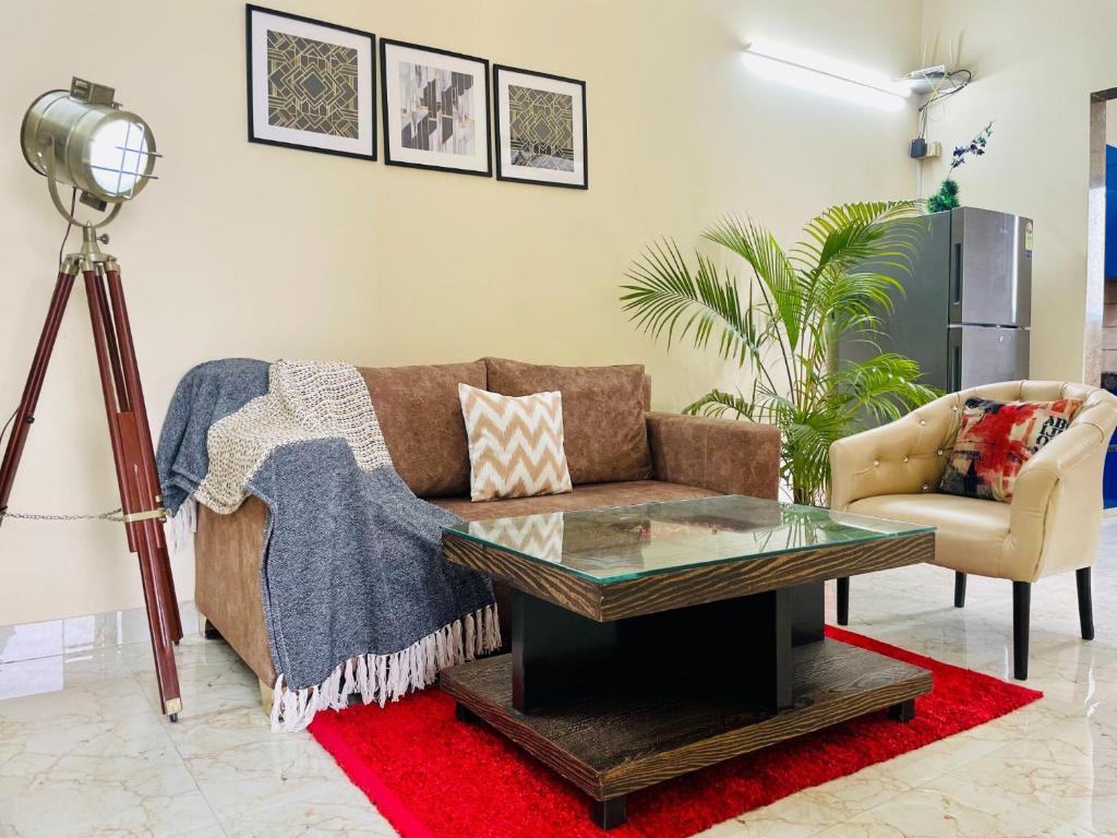 古尔冈Olive Service Apartments - Artemis的带沙发和咖啡桌的客厅