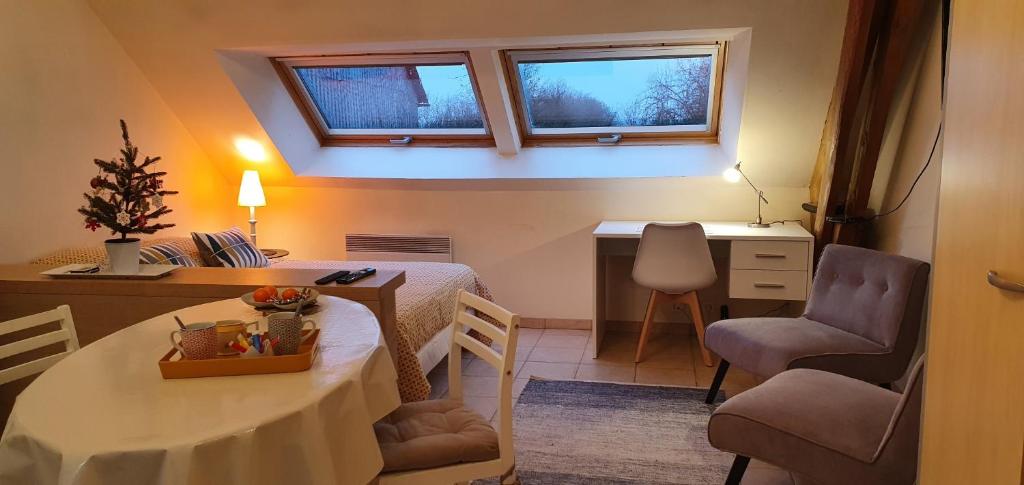 Villers-CarbonnelLa Hulotte的小房间设有桌子和书桌及两个窗口