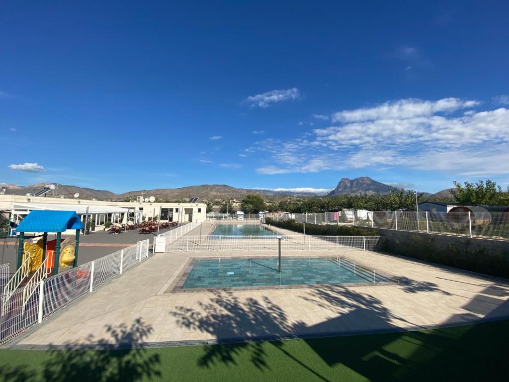 比利亚霍约萨Camping Alicante Imperium的享有游泳池的景色,背景为山脉