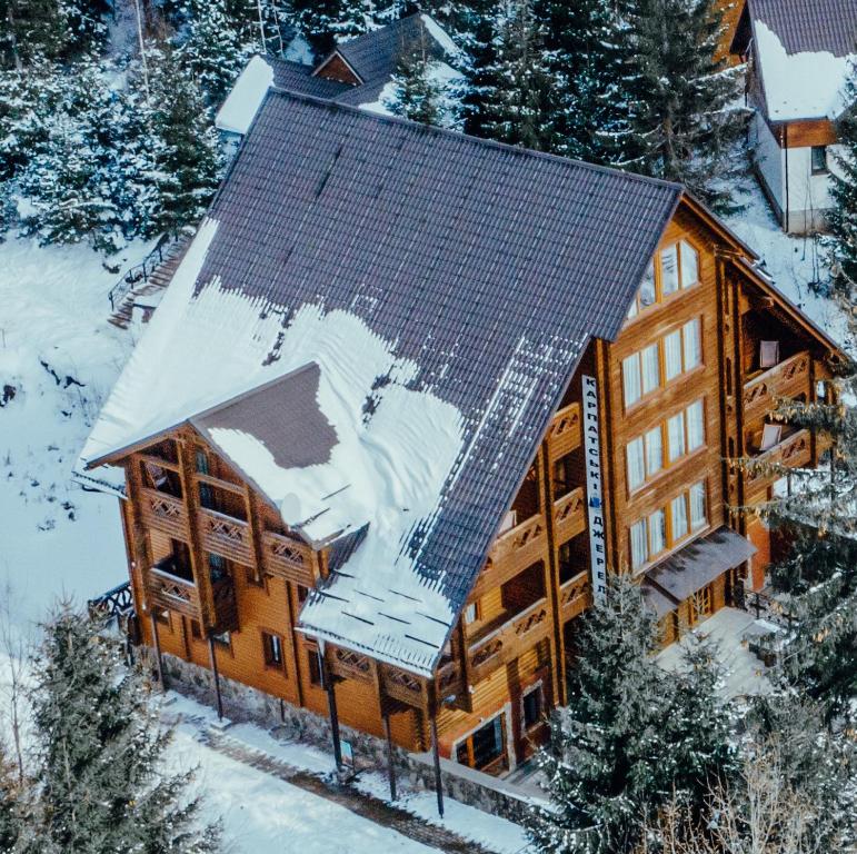 亚列姆切Karpatski Dzherela的小木屋空中景色,屋顶上有雪
