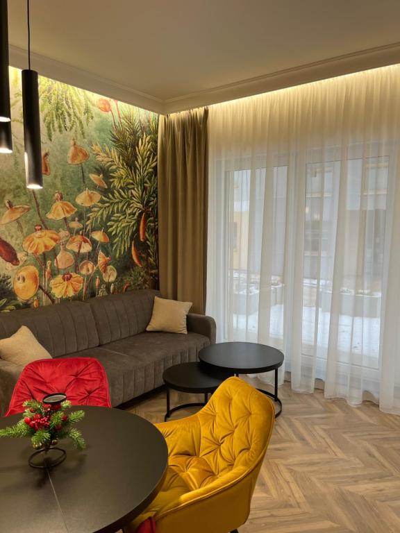 布罗德尼察Apartament Sweet Dream Longinówka的客厅配有沙发、桌子和绘画作品
