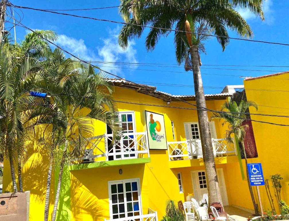 皮帕MATURI CENTRO的一座棕榈树的黄色建筑