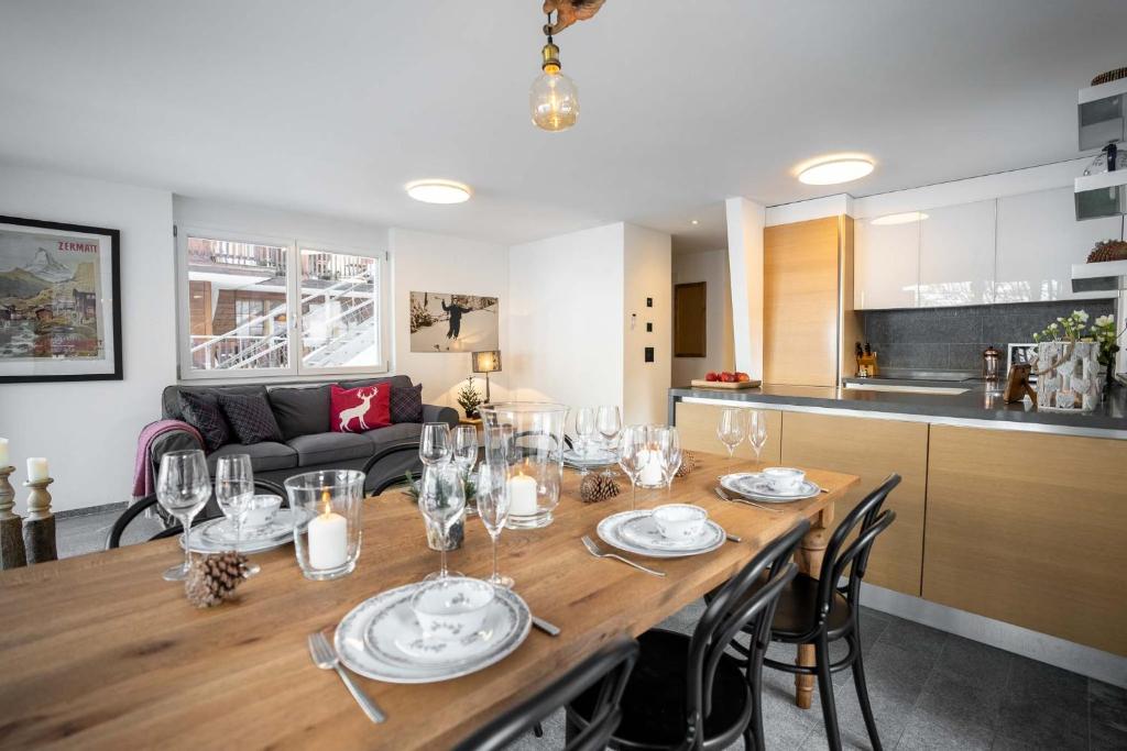 采尔马特Modern apartment with Matterhorn view的用餐室以及带大木桌的厨房。