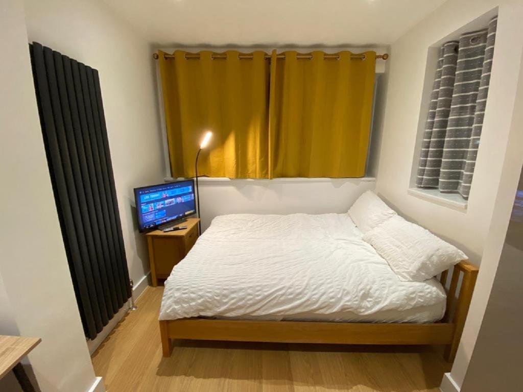 BelvedereDouble Bedroom with en-suite shower & free parking的一间小卧室,配有一张床和电视